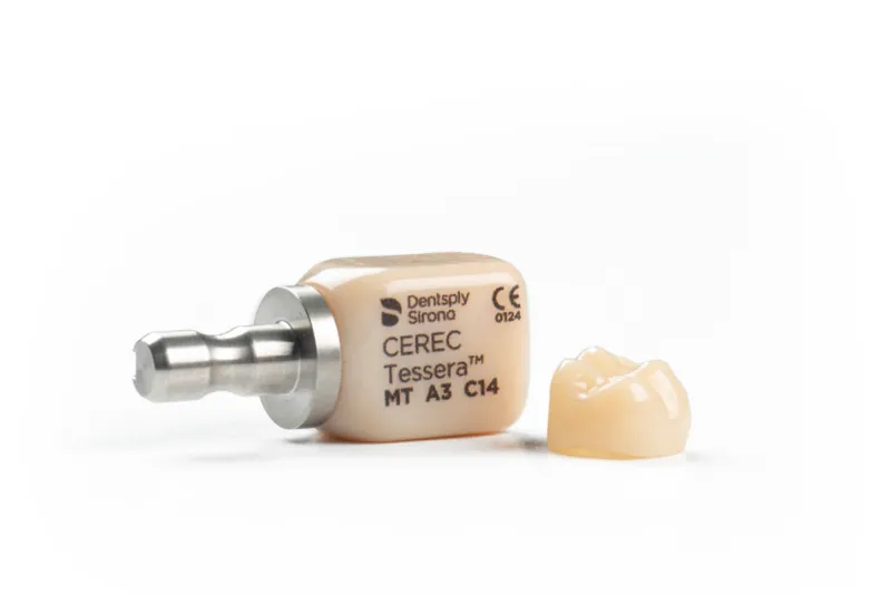 Bloque de cerámica CEREC Tessera de Dentsply Sirona junto a una corona fresada — coronas CAD/CAM en una sesión en Logroño